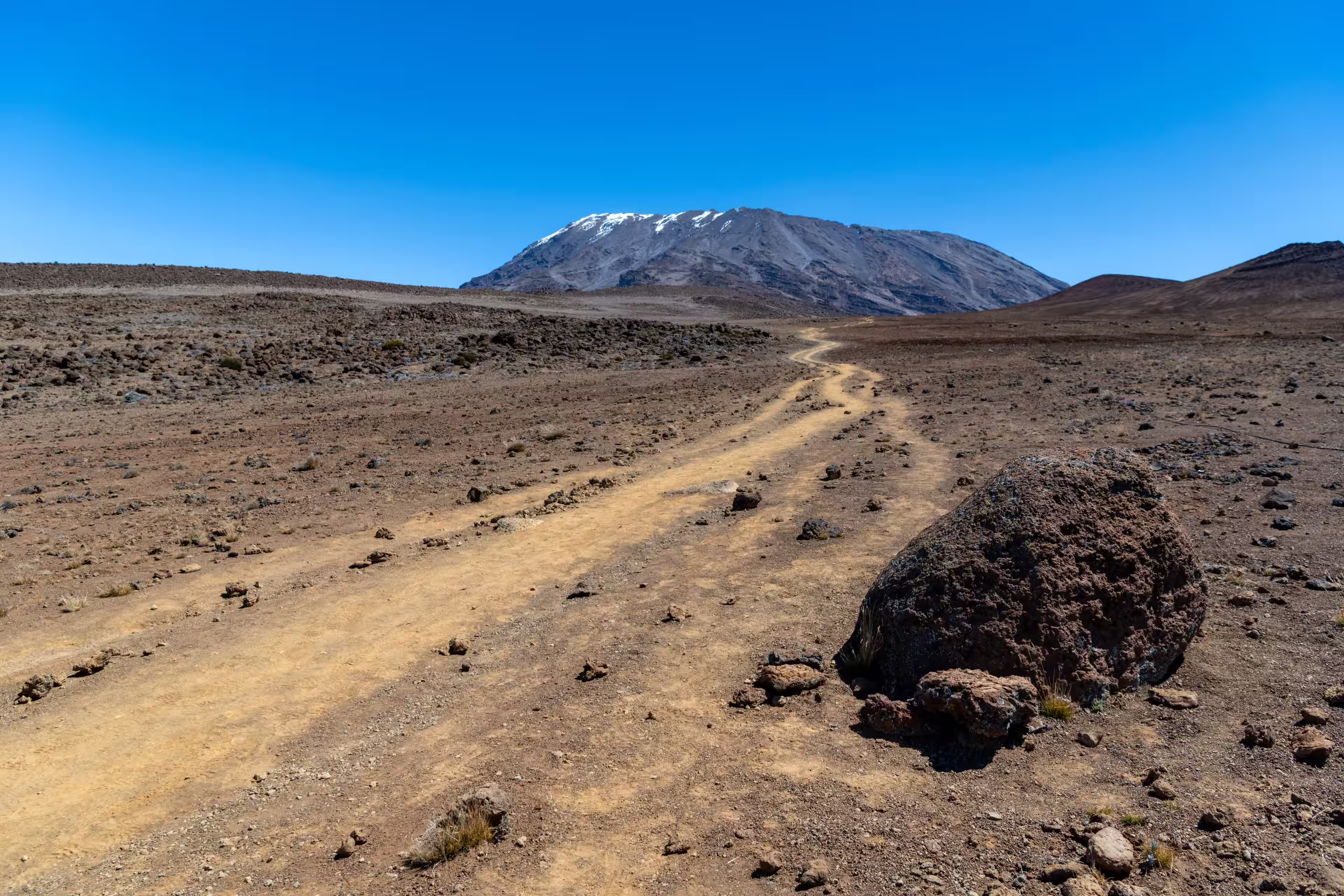 Le sentier d'ocre, seul, vers la neige